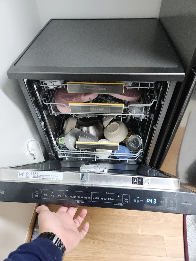 강남 식기세척기 설치 — 하부장 개구부에 반빌트인 본체를 밀어 넣는 작업자