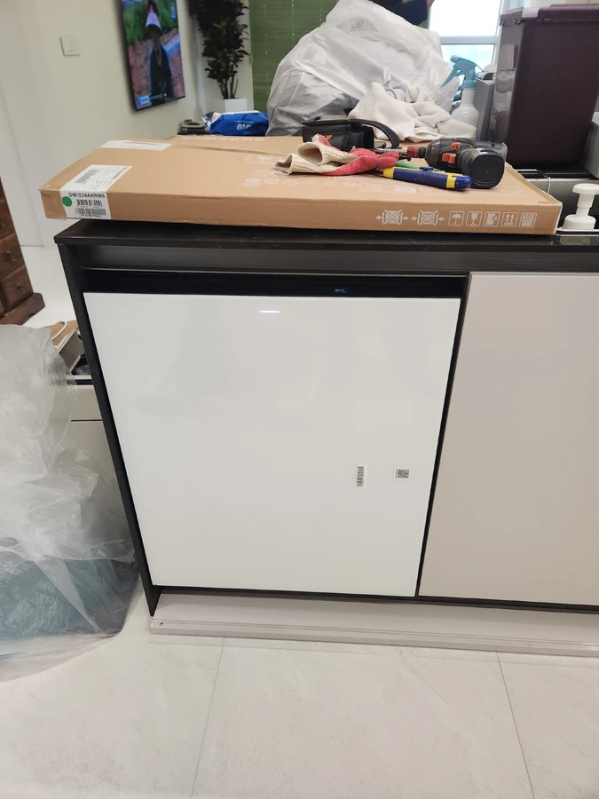 반빌트인 식기세척기 설치를 마치고 상판과 도어 틈을 점검하는 작업자